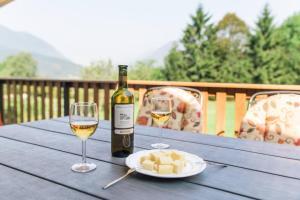 a bottle of wine and two glasses on a table at Hisa Smast in Kobarid
