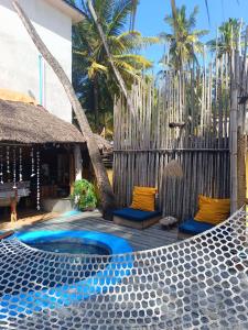 a resort patio with a hot tub and chairs at Karibuni Marafiki Villa in Bwejuu