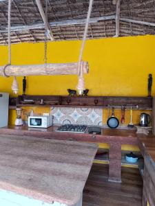 a kitchen with a counter and a yellow wall at Karibuni Marafiki Villa in Bwejuu