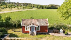 费尔耶斯塔登Röhällastugan的一座红色的小房子和一大片田野