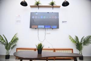 a tv hanging on a wall with a table at Unit 01 Homestay Private pool & Netflix Muar in Sungai Mati