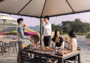 a group of people standing around a table with food at OakValley Resort Hills Village in Wonju