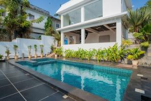 an image of a swimming pool in front of a house at Lavish Apartments with Pool Candolim Luxfort in Candolim