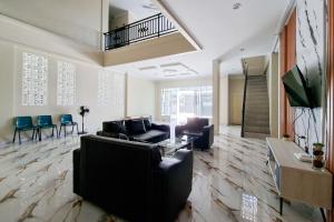 a living room with a couch and a table at Sans Hotel Bliss Pekanbaru in Sultan Syarif Kasim II International Airport