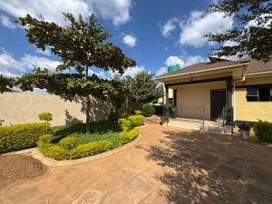 ein Haus mit einem Baum und einer Auffahrt in der Unterkunft Zachepa Family House in Lilongwe