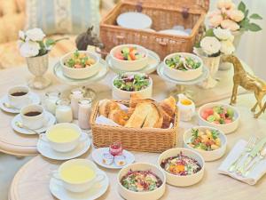 a table topped with dishes of food and a basket of bread at Auberge de Primavera in Karuizawa