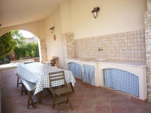 eine Küche mit einem Tisch und einem Waschbecken sowie einem Tisch und Stühlen in der Unterkunft Villa Marino in Mazara del Vallo