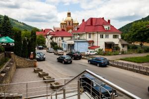 a town with cars driving down a street with buildings at Korali in Yaremche
