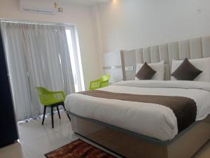 Un dormitorio con una cama grande y dos sillas. en Avantika Hotel, en Bharwain
