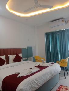 Un dormitorio con una cama con toallas. en Avantika Hotel, en Bharwain