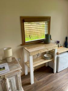 a wooden table with a window in a room at Kerrib Farm Shepherds Hut in Pomeroy +34 photos