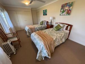 una habitación de hotel con dos camas y una silla en Lorn Farm Stay, en Lorn