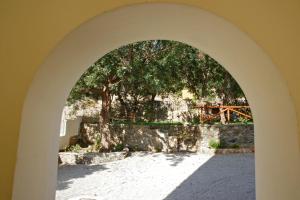 an archway with a stone wall and a tree at Aretousa in Sougia
