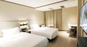 Hanting Hotel Shenzhen Baoan Xixiang Taoyuanju客房内的一张或多张床位