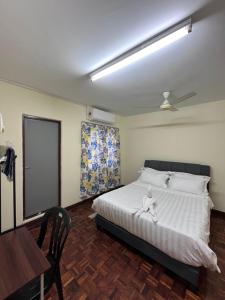 una camera con letto bianco, scrivania e tavolo di 4 BR House at Seksyen 4 BB Bangi a Bandar Baru Bangi