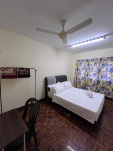 una camera con letto, tavolo e ventilatore a soffitto di 4 BR House at Seksyen 4 BB Bangi a Bandar Baru Bangi