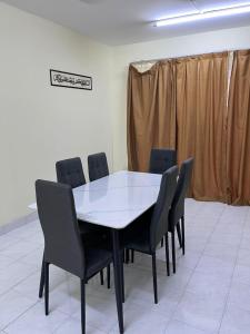 una sala conferenze con tavolo e sedie bianchi di 4 BR House at Seksyen 4 BB Bangi a Bandar Baru Bangi