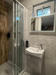 a bathroom with a sink and a shower and a mirror at Turawa Lake Residence in Turawa +29 photos