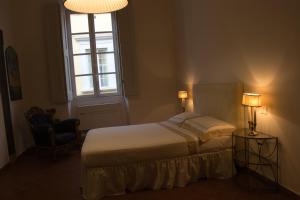 a bedroom with a bed and a window and a chair at Michelangelo Escape Suite in Pietrasanta