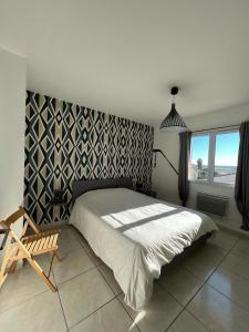 una camera da letto con un letto e una sedia di Maison avec piscine privée entièrement climatisée a Sauvian Altre 12 foto