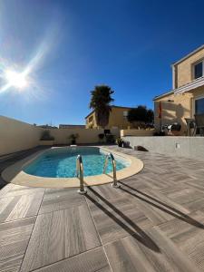 una piscina in mezzo a un cortile di Maison avec piscine privée entièrement climatisée a Sauvian