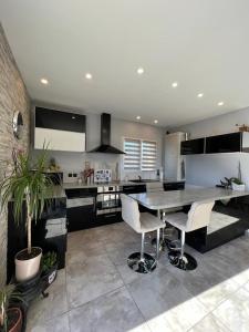 una grande cucina con tavolo e sedie di Maison avec piscine privée entièrement climatisée a Sauvian