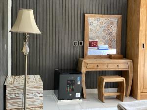 a room with a lamp and a table and a desk at Gelih Bungalow Nusa Penida in Nusa Penida