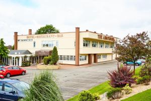 a building with cars parked in a parking lot at Abbotsford Hotel in Dumbarton