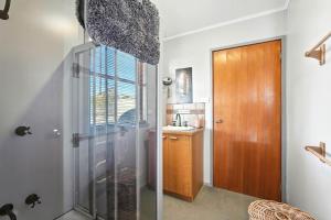 a bathroom with a glass shower and a sink at Bull Tavern Cabin Cozy Lakeside Escape in Miena Tasmania in Miena +20 photos