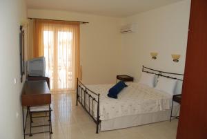 Un dormitorio con una cama con una almohada azul encima. en Zeus Paradise Hotel Ammoudia, en Ammoudia 15 fotos más