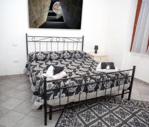 a bedroom with a black bed with pillows on it at B&B San Leonardo Dualchi in Dualchi