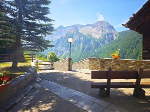 a park bench with a view of a mountain at Hostdomus - Abete 2 Apartment in Grange Sises