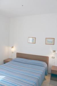 a bedroom with a bed with a blue and white striped blanket at Casa Roberta in Capoliveri