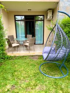 un columpio en un patio con mesa y sillas en Green life private garden studio, en Sozopol