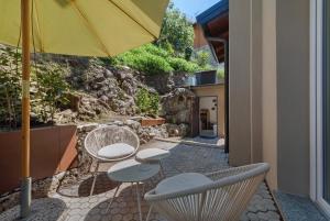 a patio with two chairs and an umbrella at Casa Teresa Suite in Como in Como