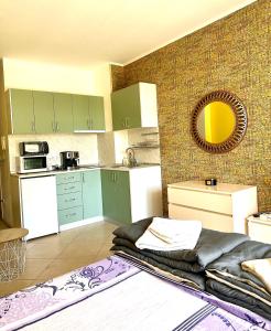 una cocina con armarios verdes y una cama en una habitación en Green life private garden studio, en Sozopol