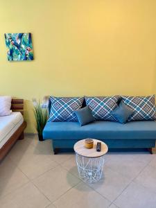 Una sala de estar con un sofá azul y una mesa. en Green life private garden studio, en Sozopol