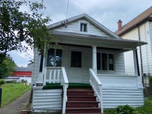 a white house with a porch and stairs at Mabsarkerllc in Niagara Falls