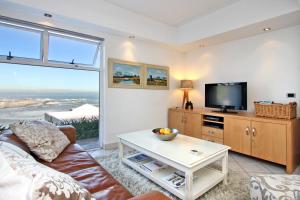 a living room with a couch and a tv at Camps Bay Terrace Suite in Cape Town