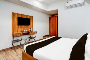 阿格拉Super Hotel O Kargil Complex Formerly Saarthi Inn的一间卧室，配有一张床、一张书桌和一台电视