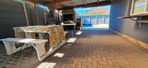 a patio with a table and a bench on a building at Murray Guest Suite in Goodwood