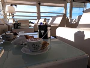 a table with two cups of coffee and cookies on a boat at GallyBi in Gallipoli