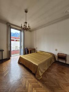 a bedroom with a bed and a large window at Appartamento completo o Camere private, Lecco Centro vicino alla stazione e al lago in Lecco