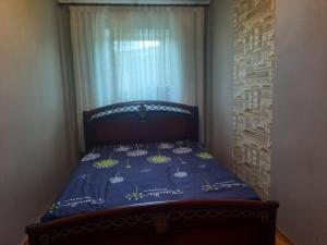 a small bedroom with a bed with a blue comforter at Дом in Odesa