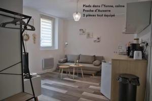 a living room with a couch and a table at Zen1 - Charmant deux pièces lumineux au cœur de Joigny in Joigny