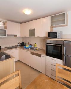 a kitchen with white cabinets and stainless steel appliances at Apartment Peran in Šibenik