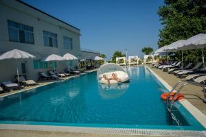 una piscina con una barca in acqua di Hotel Queen Vera a Mamaia