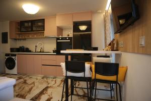 a kitchen with a counter and some chairs in it at Clock House Skiathos in Skiathos