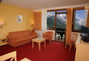 salon z kanapą, krzesłami i telewizorem w obiekcie All Inclusive - Marco Polo Alpina Familien- & Sporthotel w mieście Maria Alm am Steinernen Meer
