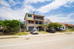 a house with two cars parked in front of it at Apartments Bartul in Sućuraj